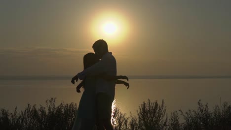 una pareja abrazándose al amanecer sobre un lago