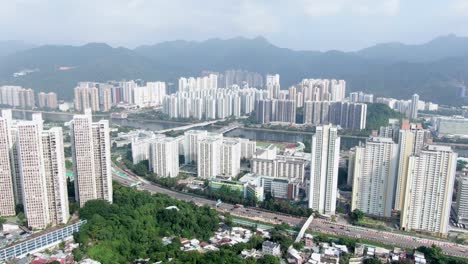 Vista-Aérea-De-Los-Mega-Edificios-Residenciales-De-Sha-Tin-De-Hong-Kong-Con-Montañas-De-Roca-De-León-En-El-Fondo