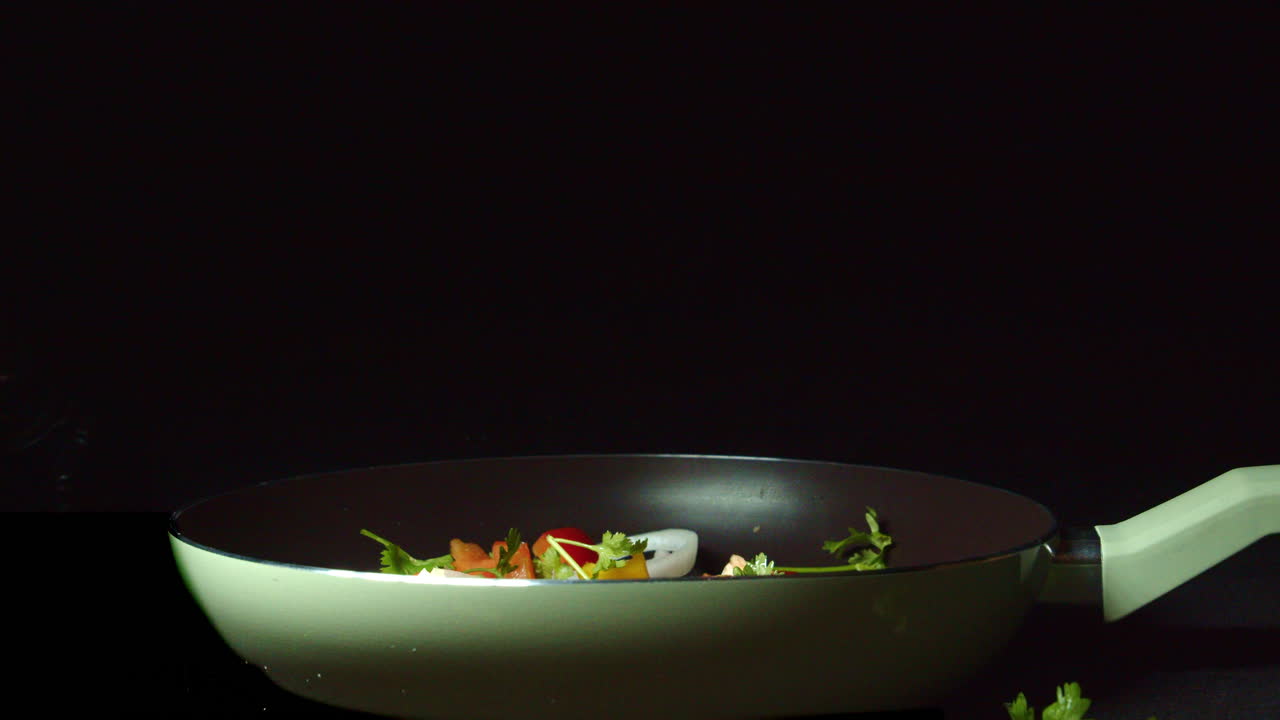 trozos de verduras picadas caen gradualmente en la sartén