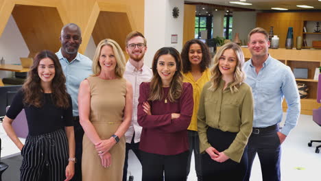 Portrait-Of-Smiling-Multi-Cultural-Business-Team-Standing-In-Modern-Open-Plan-Office