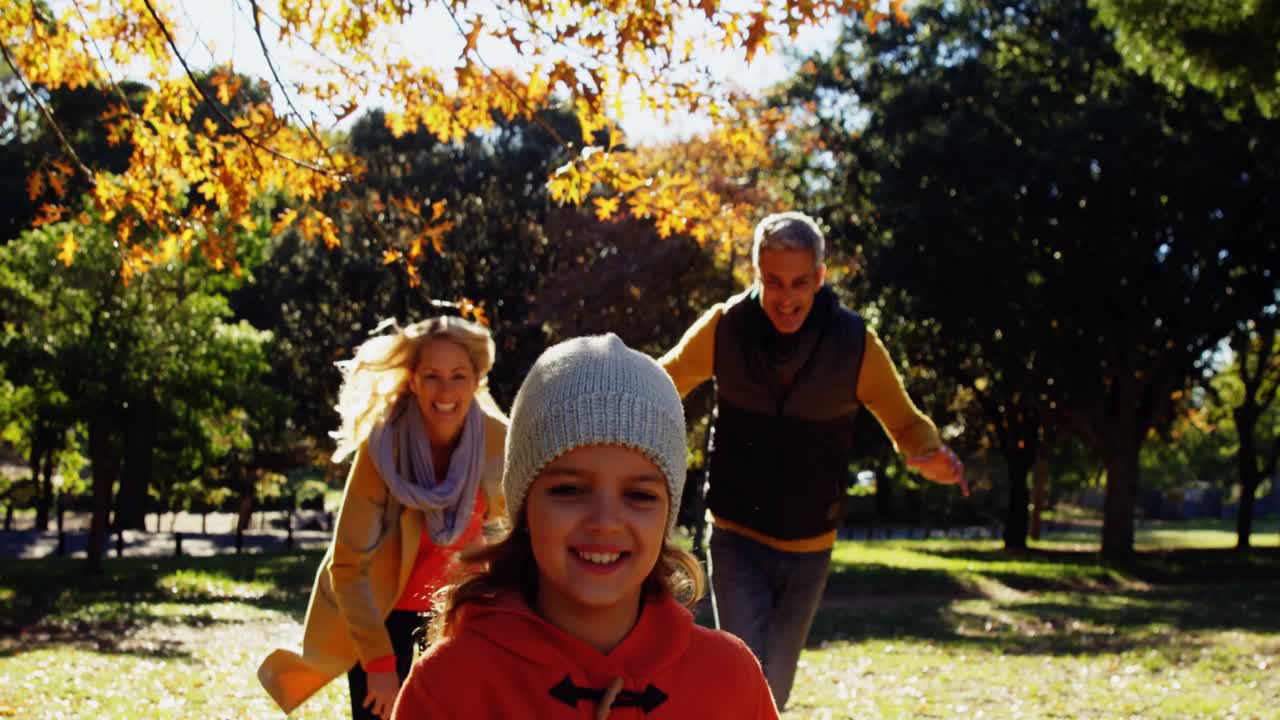 mamá y papá persiguiendo a su hija al aire libre