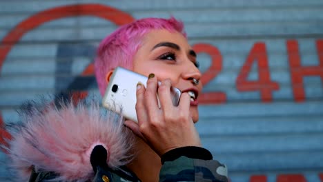 mujer de cabello rosa hablando por teléfono móvil fuera de la tienda 4k