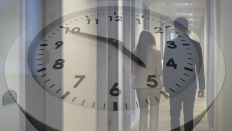 Animation-of-clock-over-diverse-coworker-sharing-ideas-and-walking-in-corridor-of-office