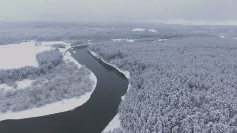 河流在冬天穿過雪覆蓋的森林