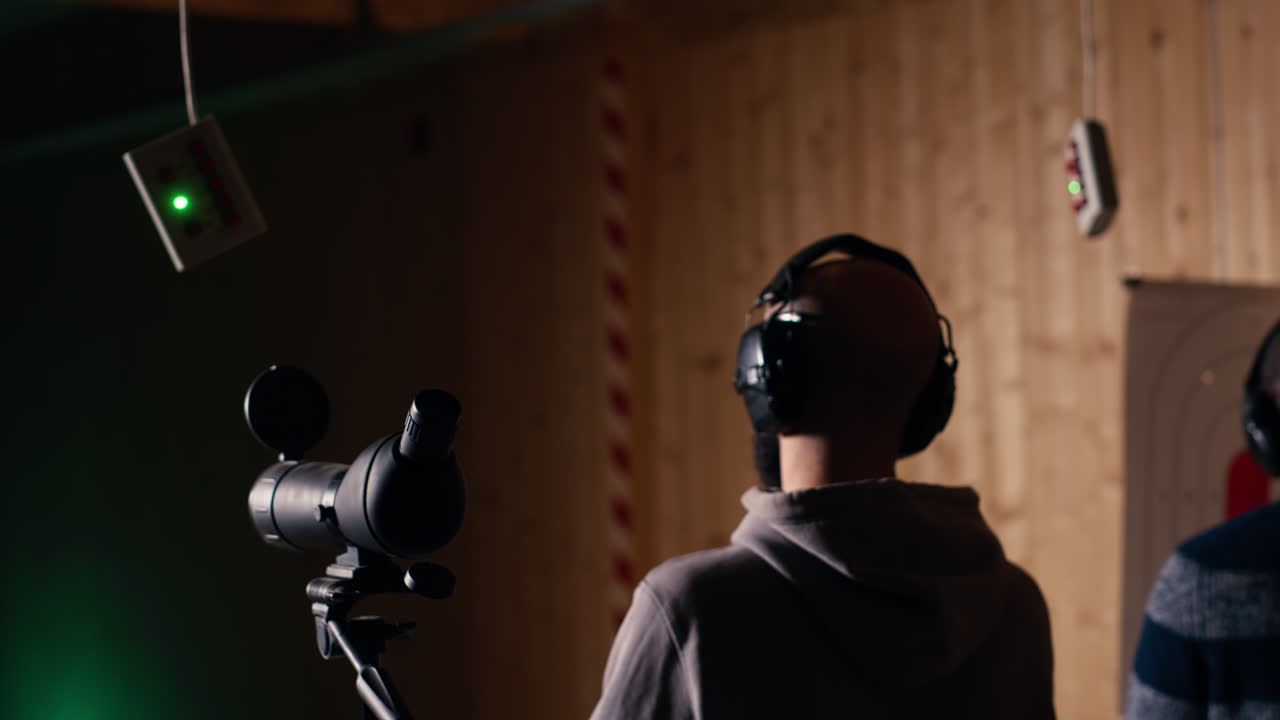 사격장 고객이 친구 에서 사격 활동을 하고, 을 비교하고 있습니다.