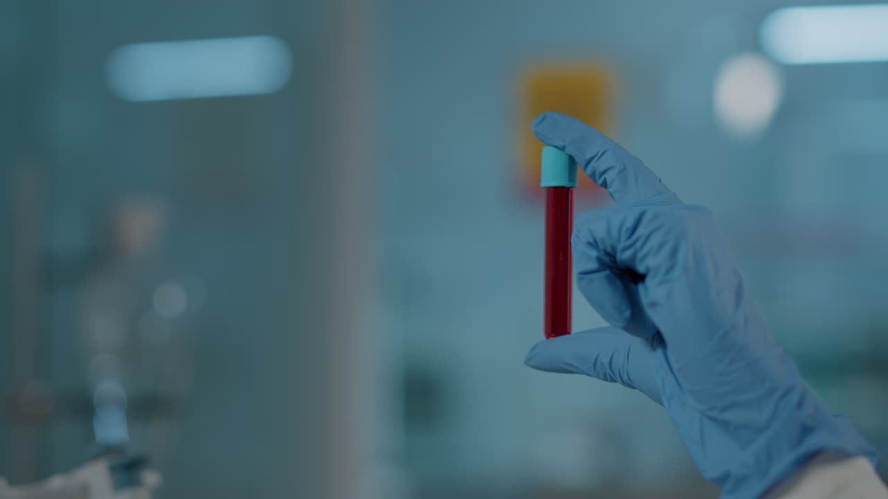 Hand with gloves holding test tube in science laboratory
