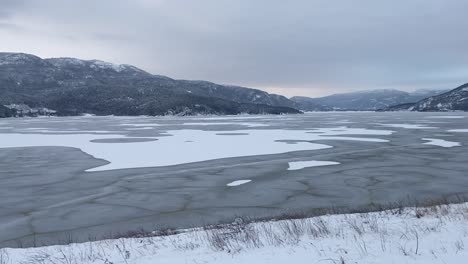 a breathtaking panorama view of krøderen, covered in ice and snow, reveals a serene winter wonderland