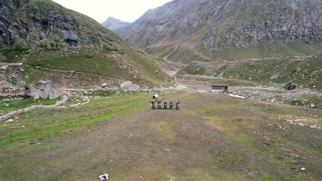 aerial dolly zoom out of motorcycle riders parked in rural valley of northern india