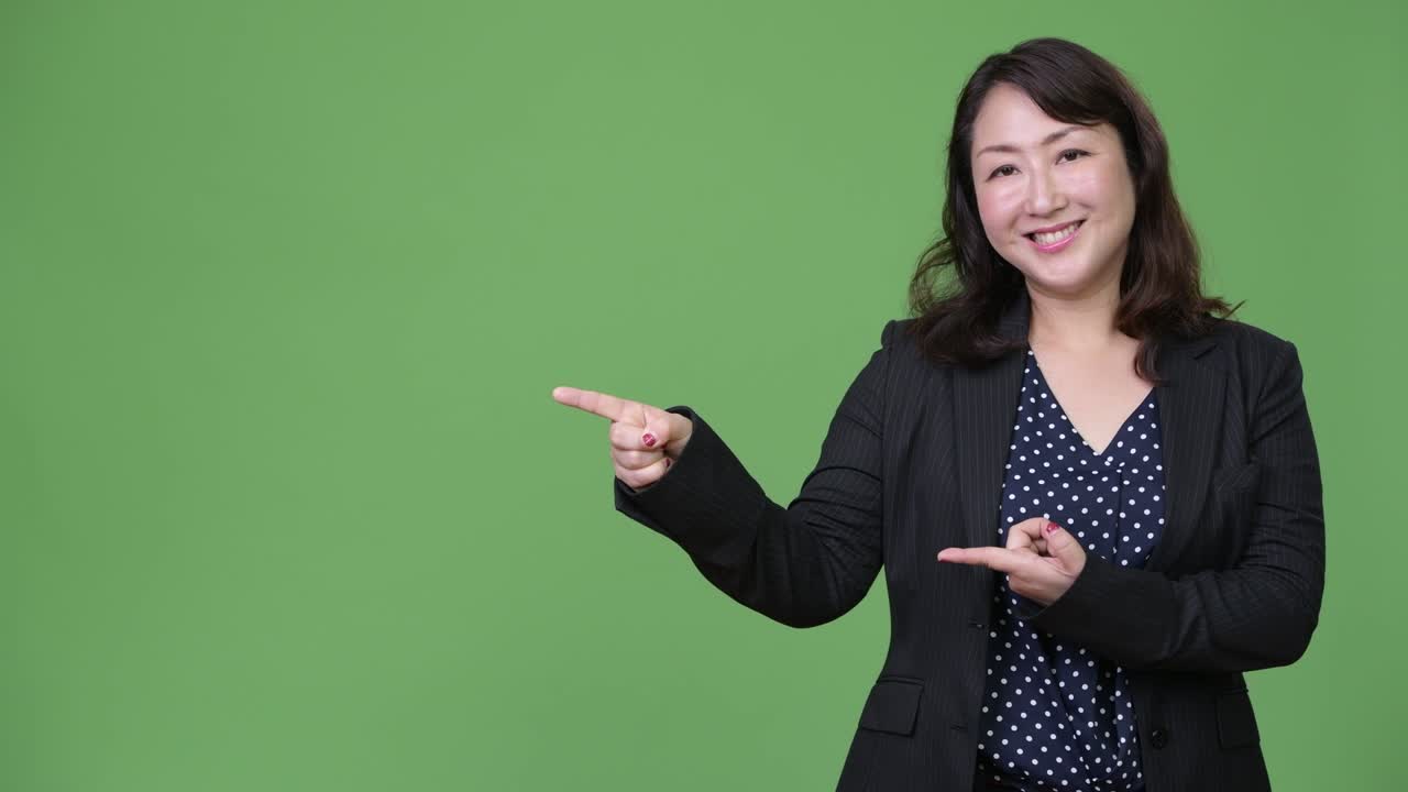 una hermosa mujer de negocios asiática madura mostrando algo