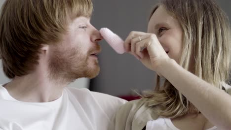 happy young couple playing with pink babys bootie