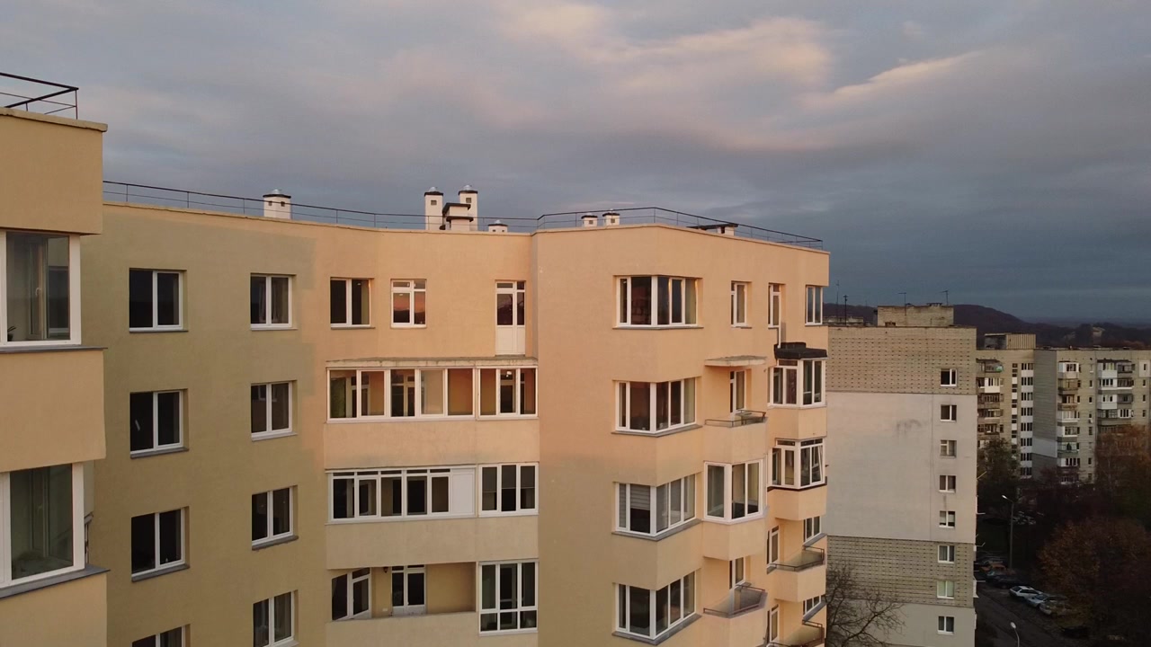 Luftfoto fra en drone, der flyver over bygninger, med optagelser af tage og arkitektur.