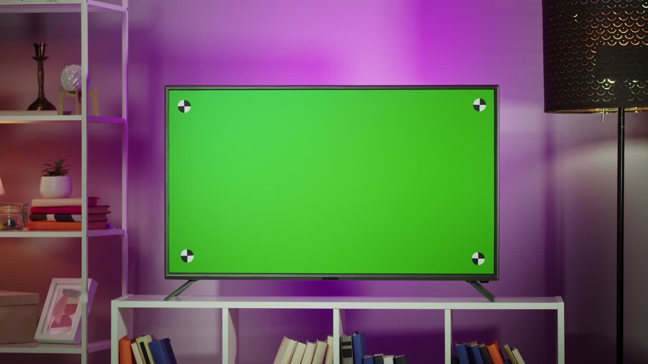 Television with chroma key close-up. Green screen display on tv set in cozy living room in evening.