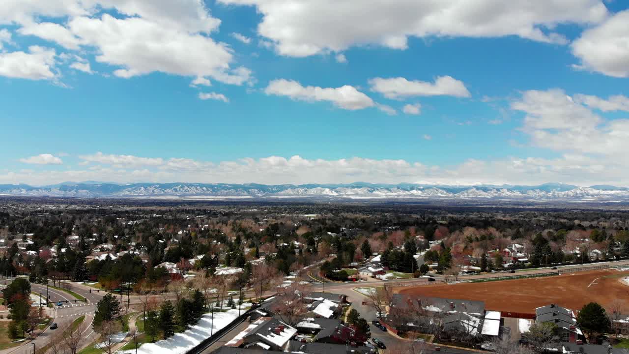 덴버 교외의 드론 팬, 수평선에 눈 덮인 산들
