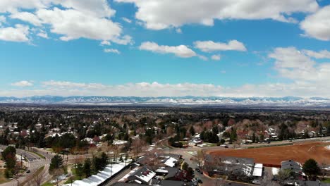 a drone pan over a denver suburb, snow capped mountains on the horizon