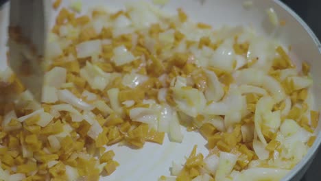 cámara lenta mezclando cebollas y zanahorias en sartén en 120fps