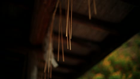 incense sticks hanging from a wooden roof