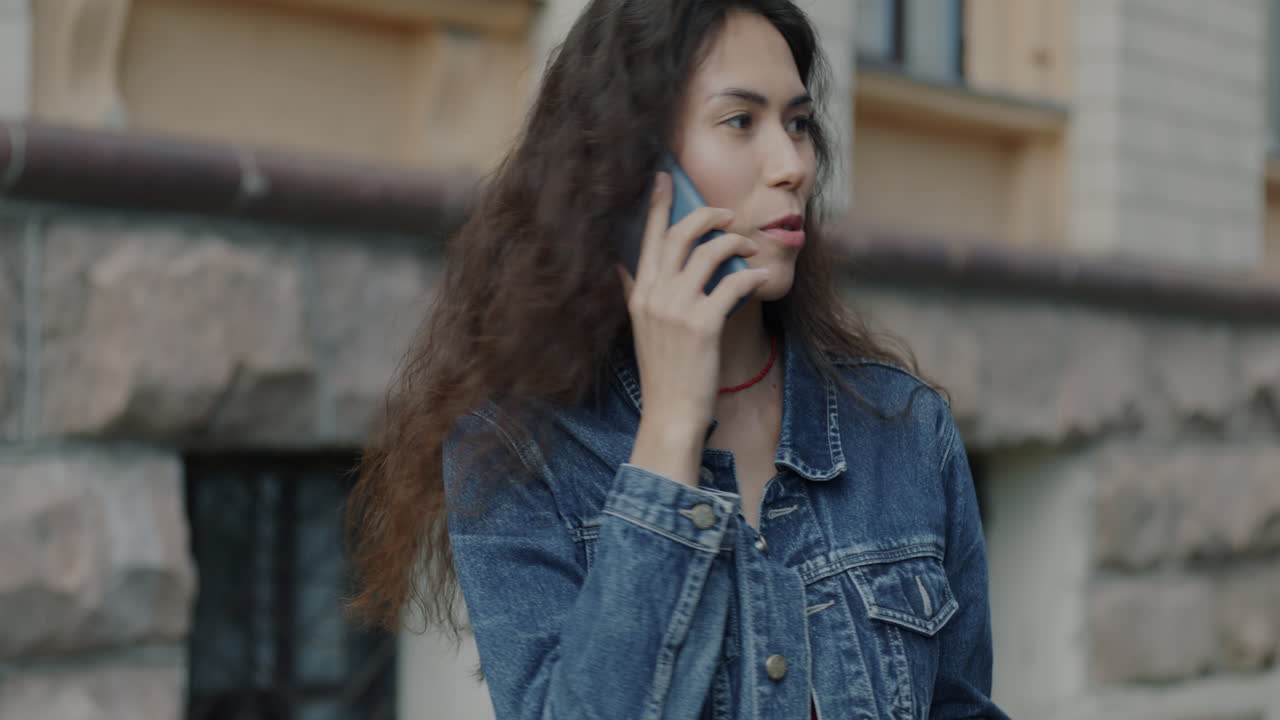 una mujer hablando por teléfono afuera.