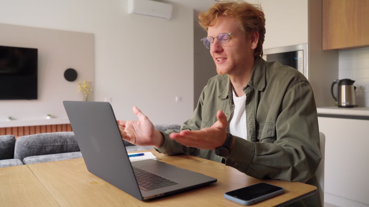 Smiling ginger irish man having video call over laptop computer at home