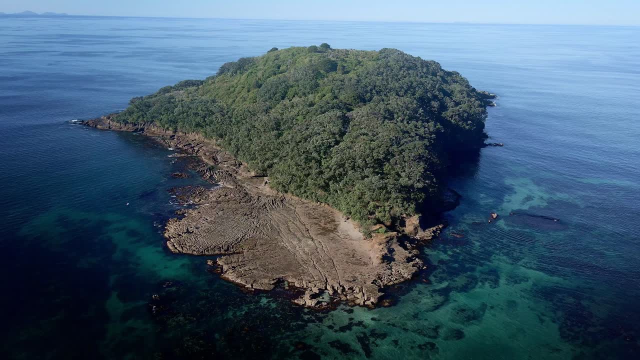 antena de órbita ancha alrededor de la hermosa isla de cabra agua de reserva marina transparente en un día soleado de verano, nueva zelanda