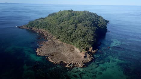 antena de órbita ancha alrededor de la hermosa isla de cabra agua de reserva marina transparente en un día soleado de verano, nueva zelanda