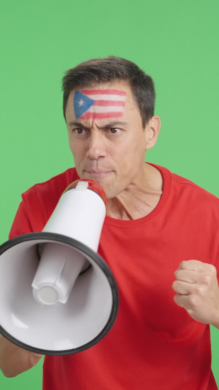 Excited man with puerto rican flag on face using a megaphone