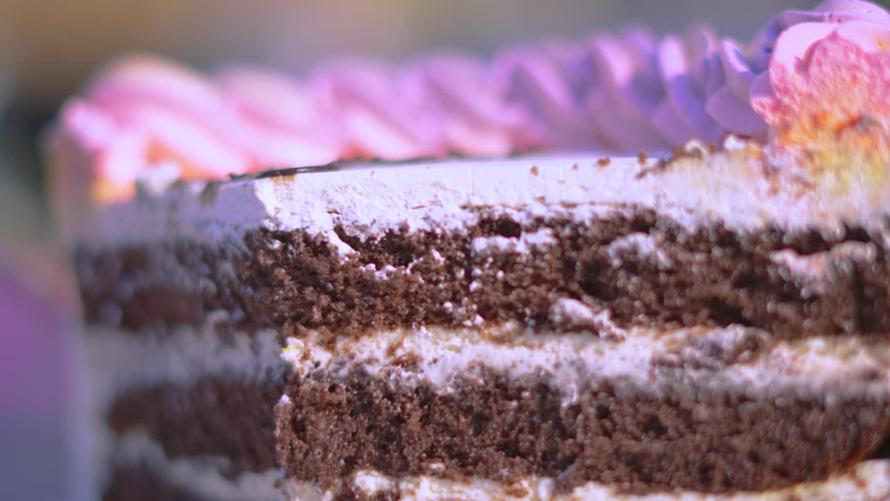 Delicious Chocolate Birthday Cake Dessert with Layers of ButterCream and Colorful Piped Whipped Cream on Top with Shallow DOF. Traditional Sweet Food Eaten for Celebration Occasions.