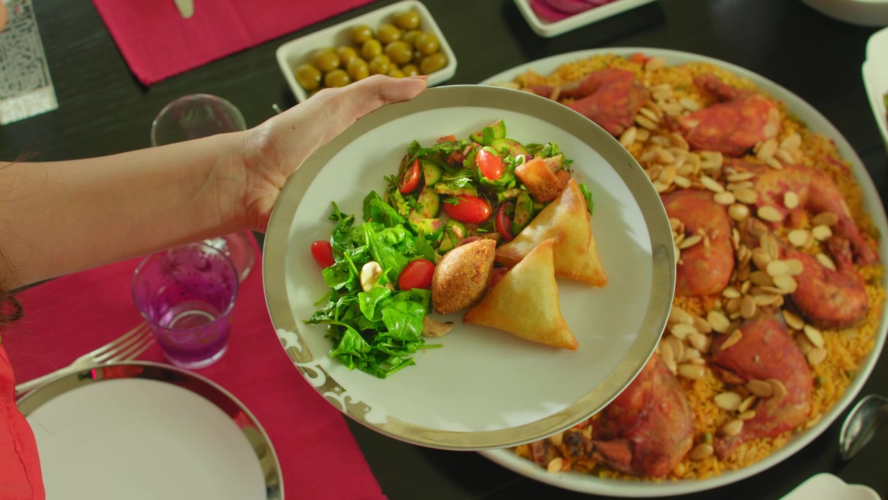 Comida Mediterrânea. Vista de cima, Mulher servindo comida árabe mediterrânea, Salada mediterrânea com quibe árabe e sambousek, filmagem 4k.