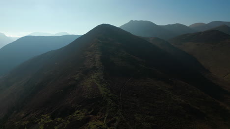 Mountain-rise-up-with-reveal-of-distant-misty-mountains-in-English-Lake-District-UK