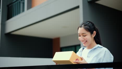 beautiful young woman receiving parcel from blue uniform delivery man f the house with good service from shopping online. courier man delivering a cardboard box postal package to destination.