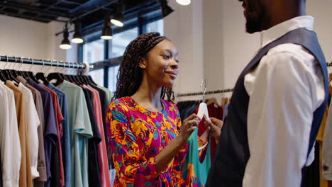 african american man and woman shopping for clothes in a boutique