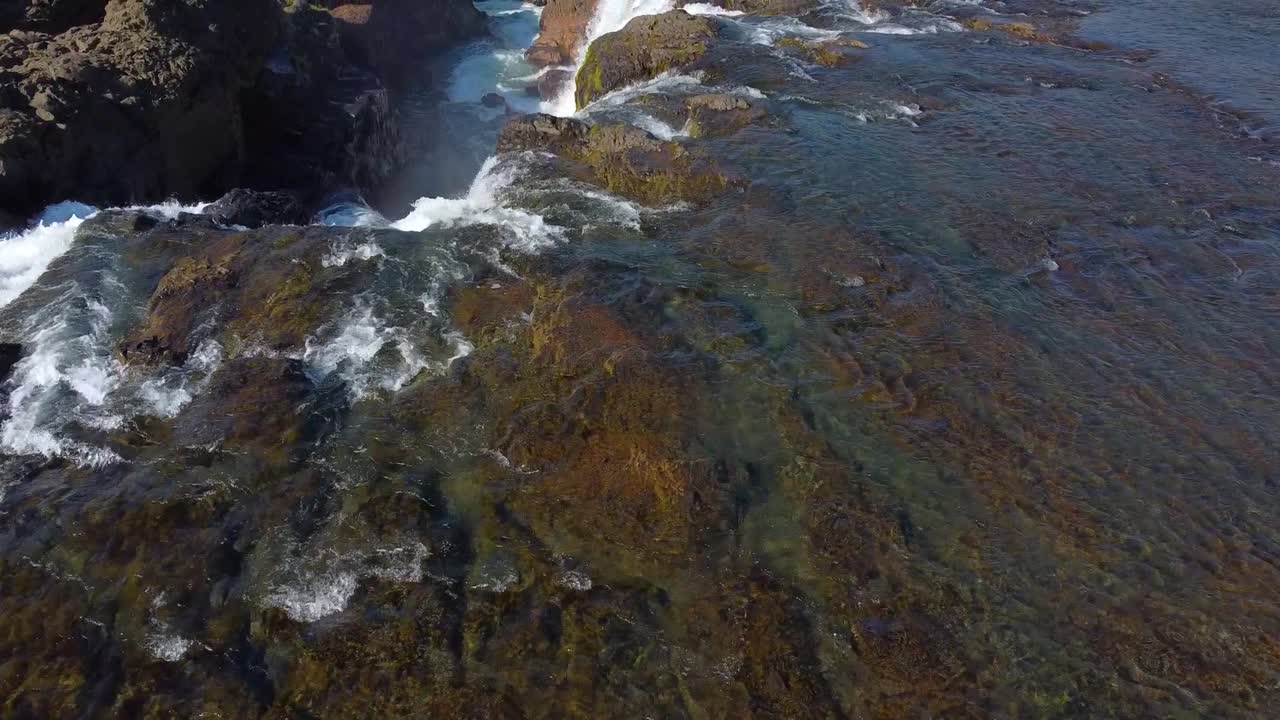 Sparkling fresh water flowing down the Kolufossar waterfall in Iceland springtime, drone view