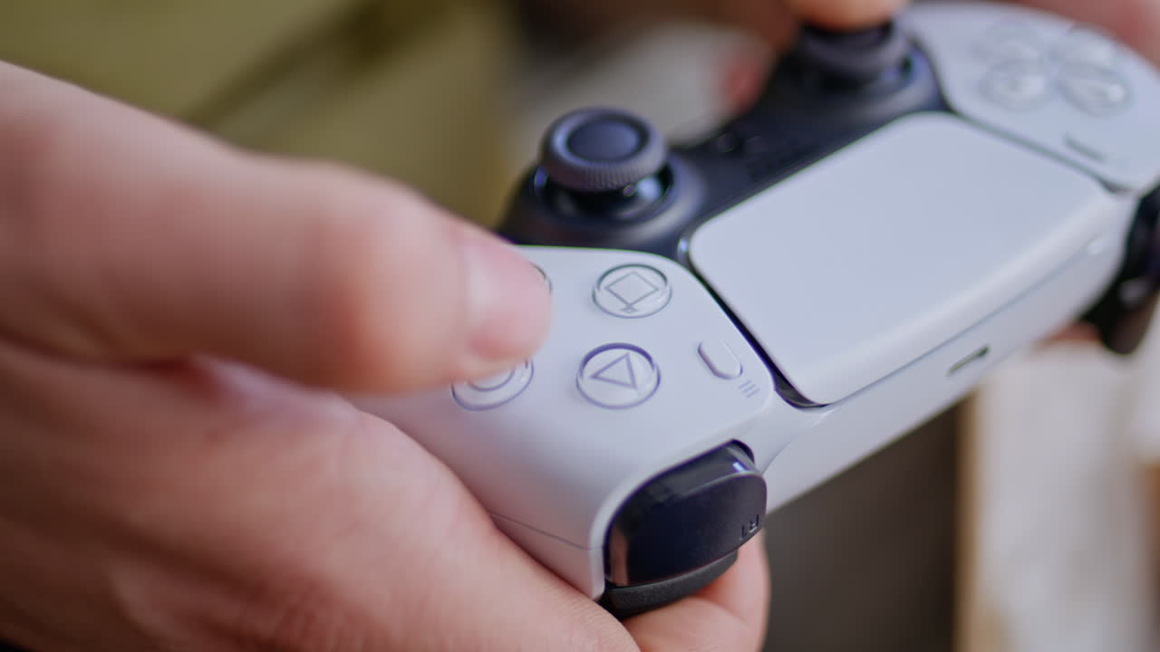 Fingers video player pushing buttons enjoying online game at light home closeup