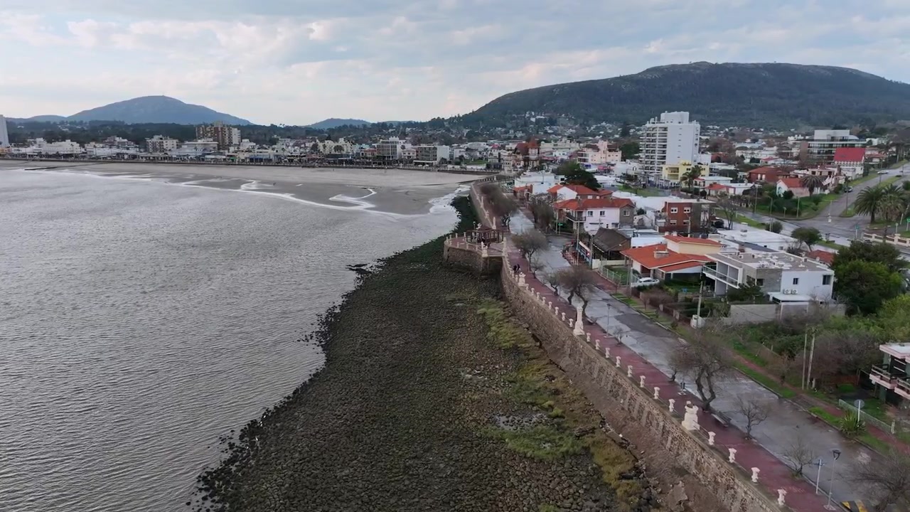 Piriápolis, la passeggiata lungomare Rambla de los Argentinos a Piriápolis, Uruguay, con la baia costiera e gli edifici bassi sullo sfondo e in primo piano.