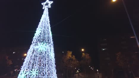 christmas tree in the middle of the city illuminated at night.