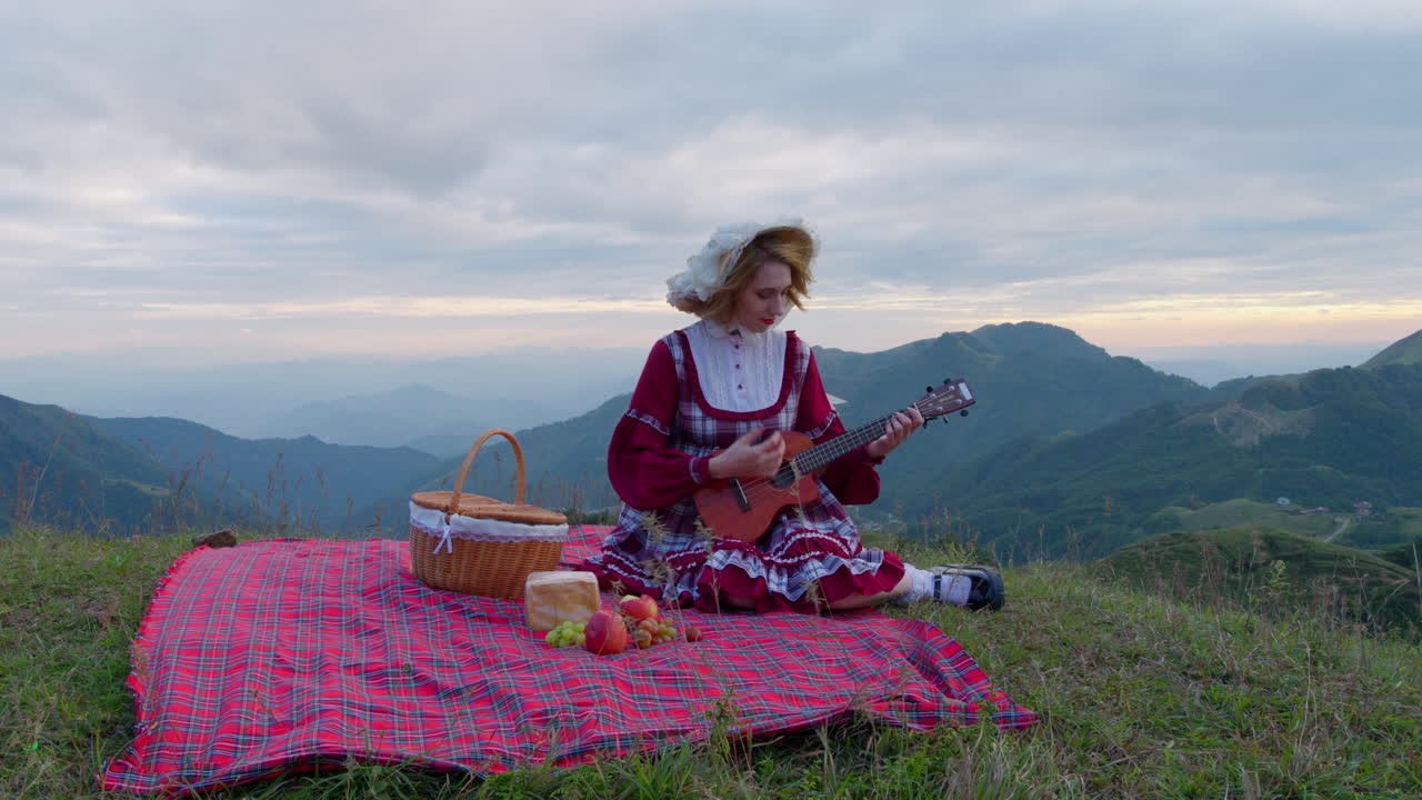 Doğada yemek yerken ukulele çalan, Rönesans ortaçağ geleneksel kıyafetleri giyen kadın model