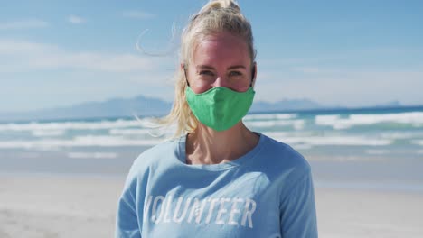 Portrait-of-caucasian-woman-wearing-volunteer-t-shirt-and-face-mask-looking-at-camera