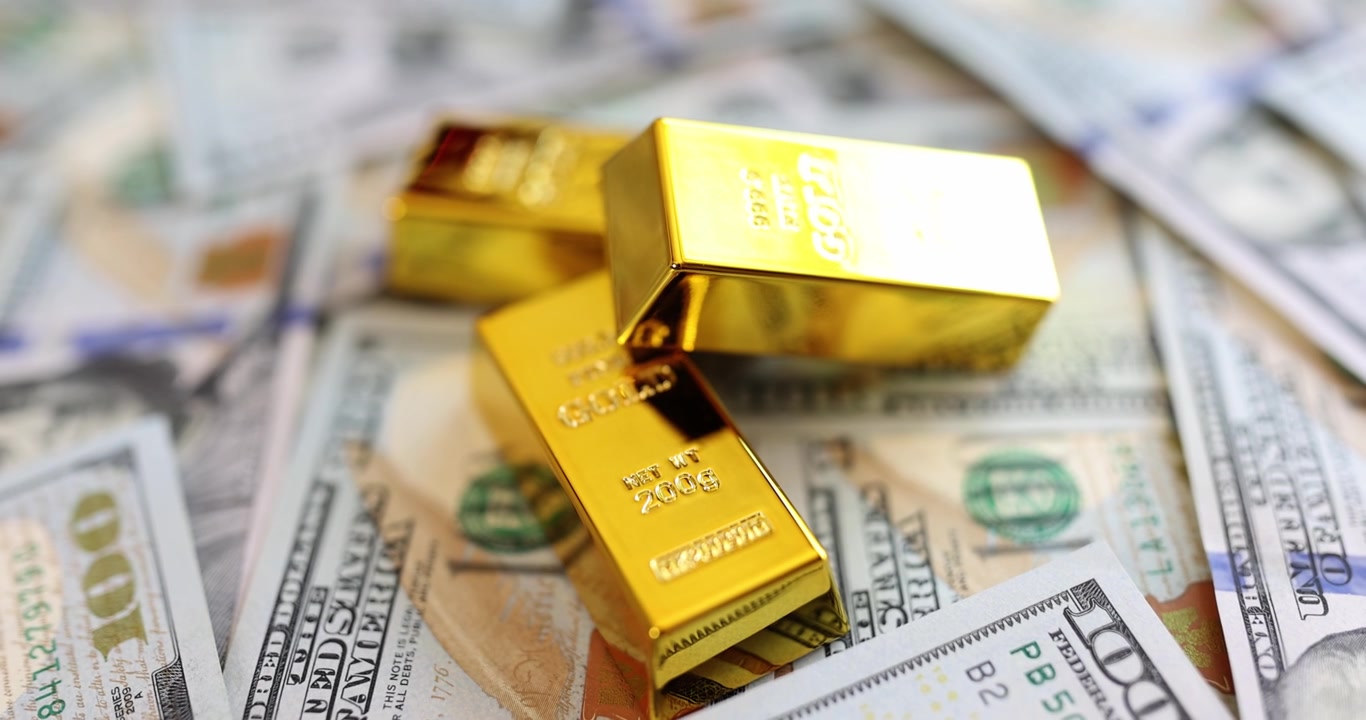 Lingotti d'oro su sfondo di dollari, primo piano