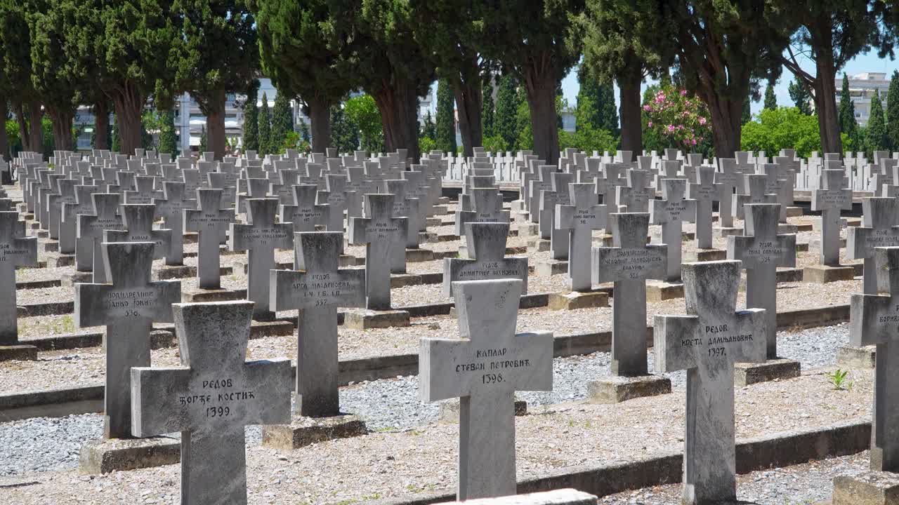 Rows of stone crosses mark the graves of Serbian soldiers at the Zeitenlik military cemetery in Thessaloniki, Greece, surrounded by cypress trees in a solemn and historic memorial site