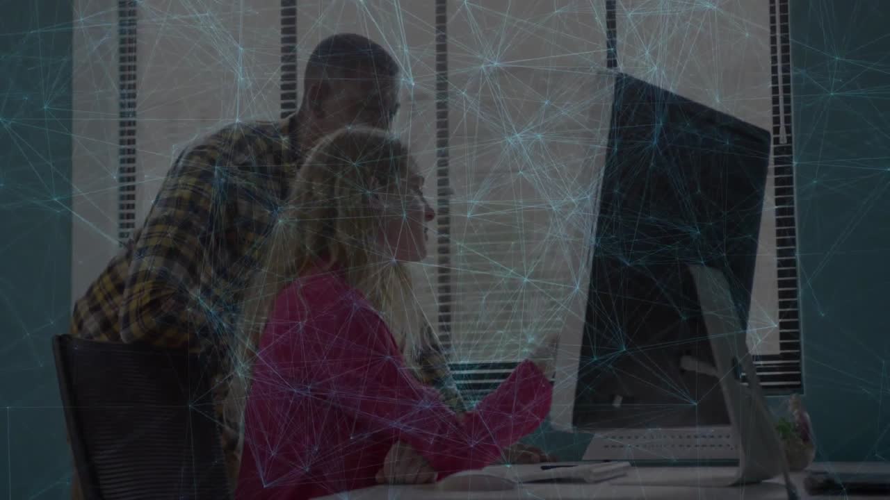 Colleagues collaborating at modern tech office desk, exploring blue digital network over computer