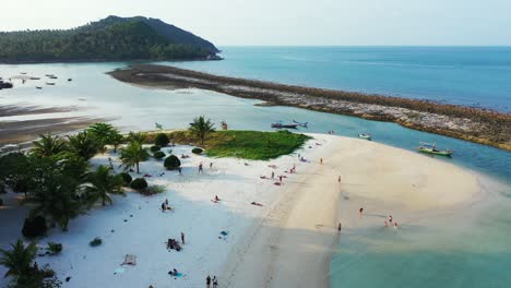 small boats surrounding sandy islet on the north coast of thailand