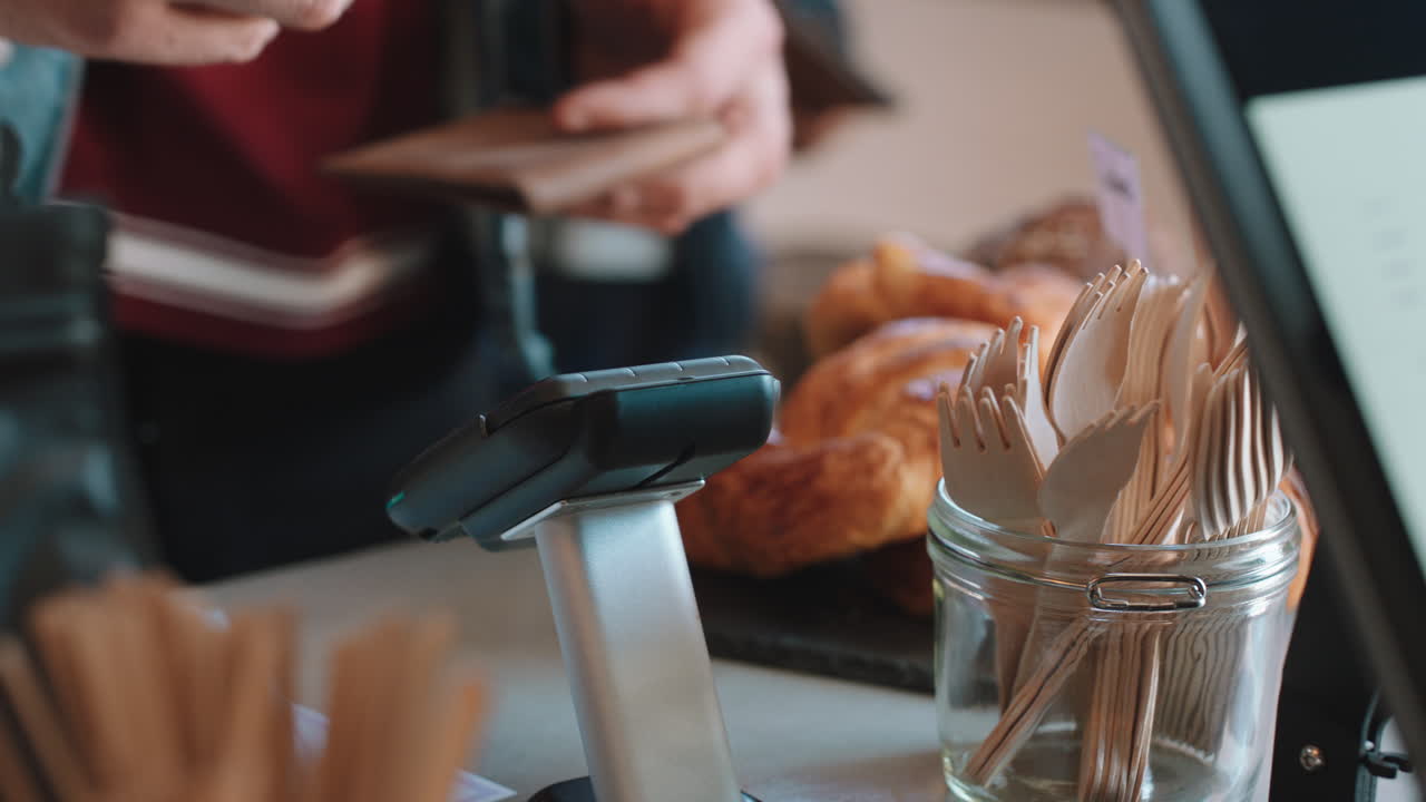 클로즈업 고객은 신용카드를 사용하여 결제하고 접촉없는 결제와 디지털 거래 서비스를 통해 카페에서 돈을 소비합니다.