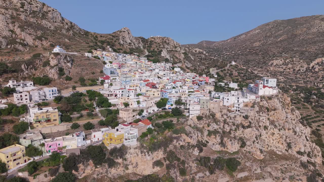 Orbiting and aerial drone footage of Menetes Village on Karpathos Island, Greece — a picturesque, colorful mountain village with traditional architecture and scenic views