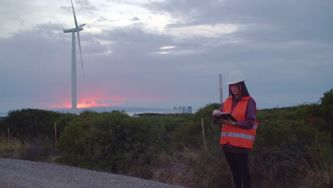 Full-shot-of-technician-engineer-inspecting-wind-turbines-with-tablet-technology