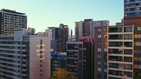 dolly in immersive of residential buildings with the entel tower in the background, downtown santiago chile, drone shot