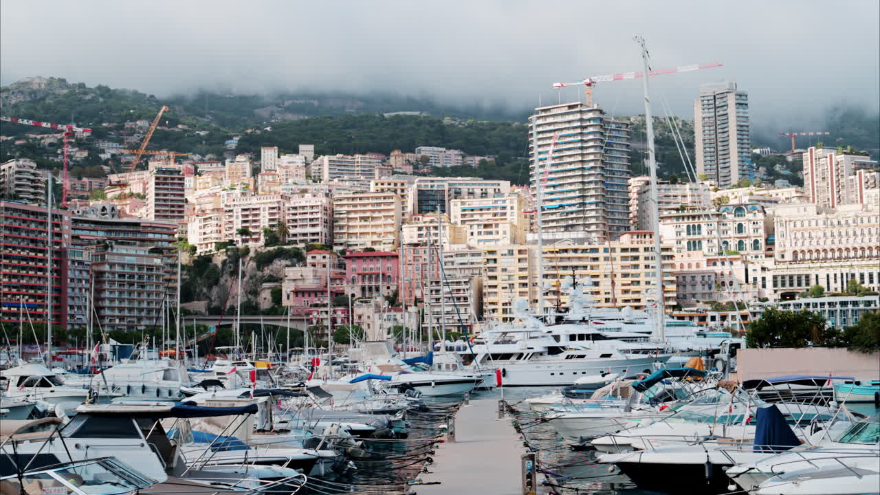 View of boats docked in the Monaco Marina with the skyline of the city on the background