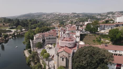 Establishing-shot-of-riverside-monastery-of-Sao-Goncalo-against-mountainous-and-townscape-background