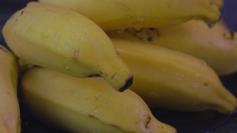 Un-Paquete-De-Plátanos-Cubiertos-De-Gotas-De-Agua-Girando-Lentamente