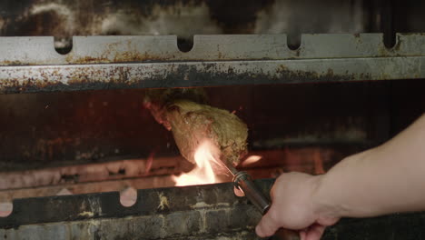 carne de barbacoa brasileña fumando bajo la parrilla de carbón, cámara lenta