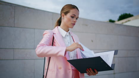ceo elegante leyendo informe en la calle de cerca. mujer de negocios comprobando documentos