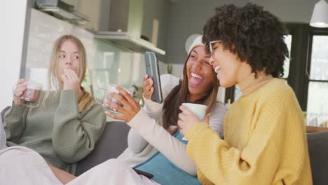 happy diverse teenager girls friends drinking coffee and talking at home, slow motion
